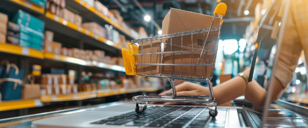 online shopping cart with packages on laptop representing ecommerce order processing