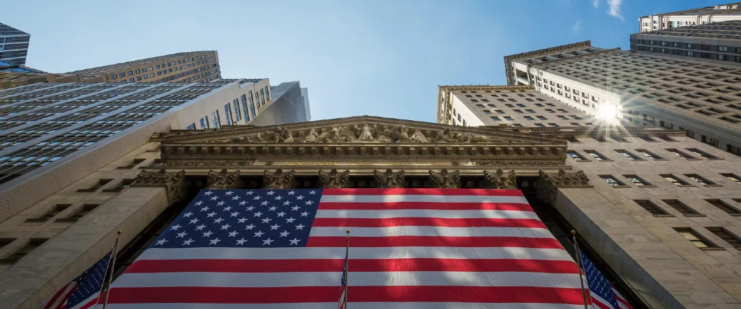 Large American flag displayed on the New York Stock Exchange building in the US financial district