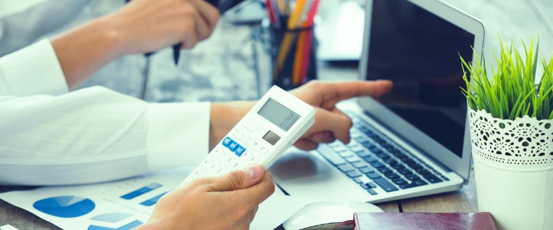 Loan processing professional reviewing financial documents and data on a laptop