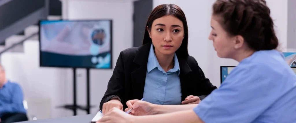Healthcare professional discussing patient referral with a medical staff member