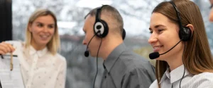Call center agents working at computer stations with service-level performance analytics