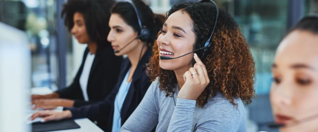 Customer service agents wearing headsets providing call center support in a modern office.