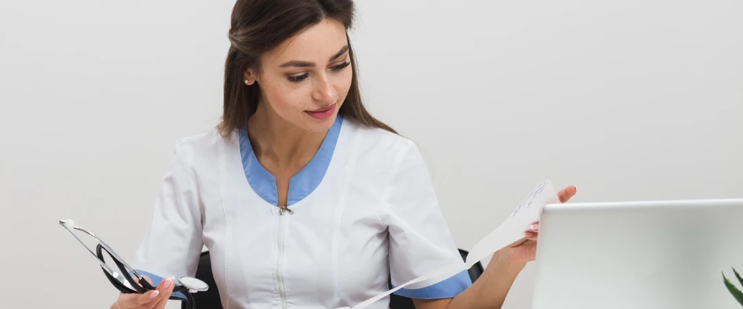 Healthcare professional reviewing telehealth billing documents on a laptop